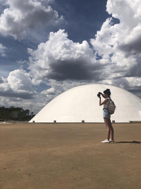 Carla Falcão em frente ao palácio da Música, no Centro Cultural Oscar Niemeyer