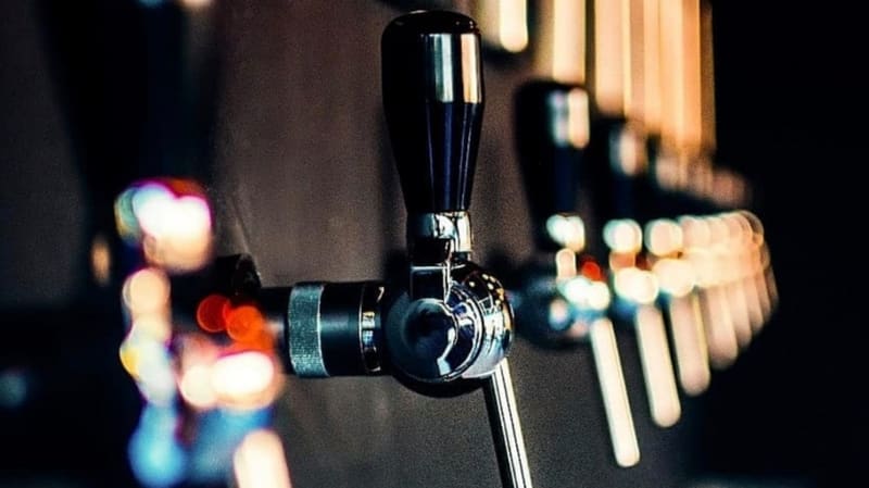 Torneiras com diferentes tipos de cervejas da Heilige Pocket Goiânia. Local também vende souvenirs da marca, como bonés e abridores | Foto: Divulgação