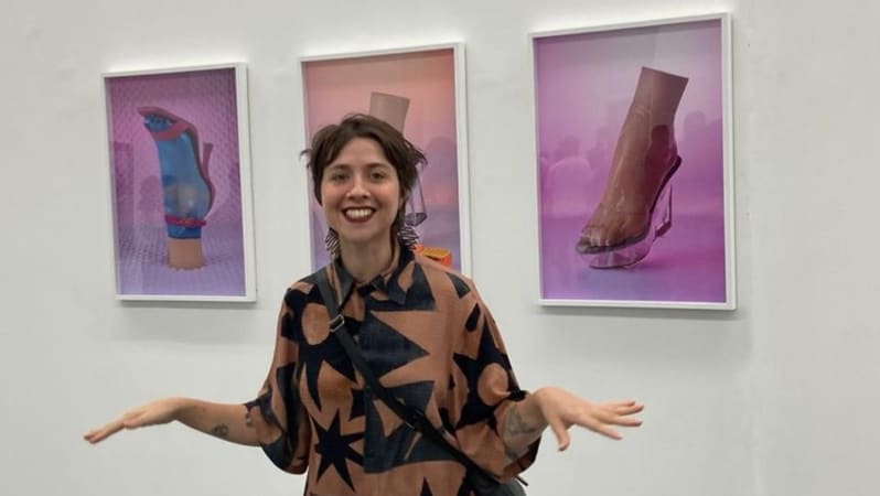 Artista Daniela Marques em frente a quadros da exposição  "Desejo LTDA." | Foto: Mateus Cecílio